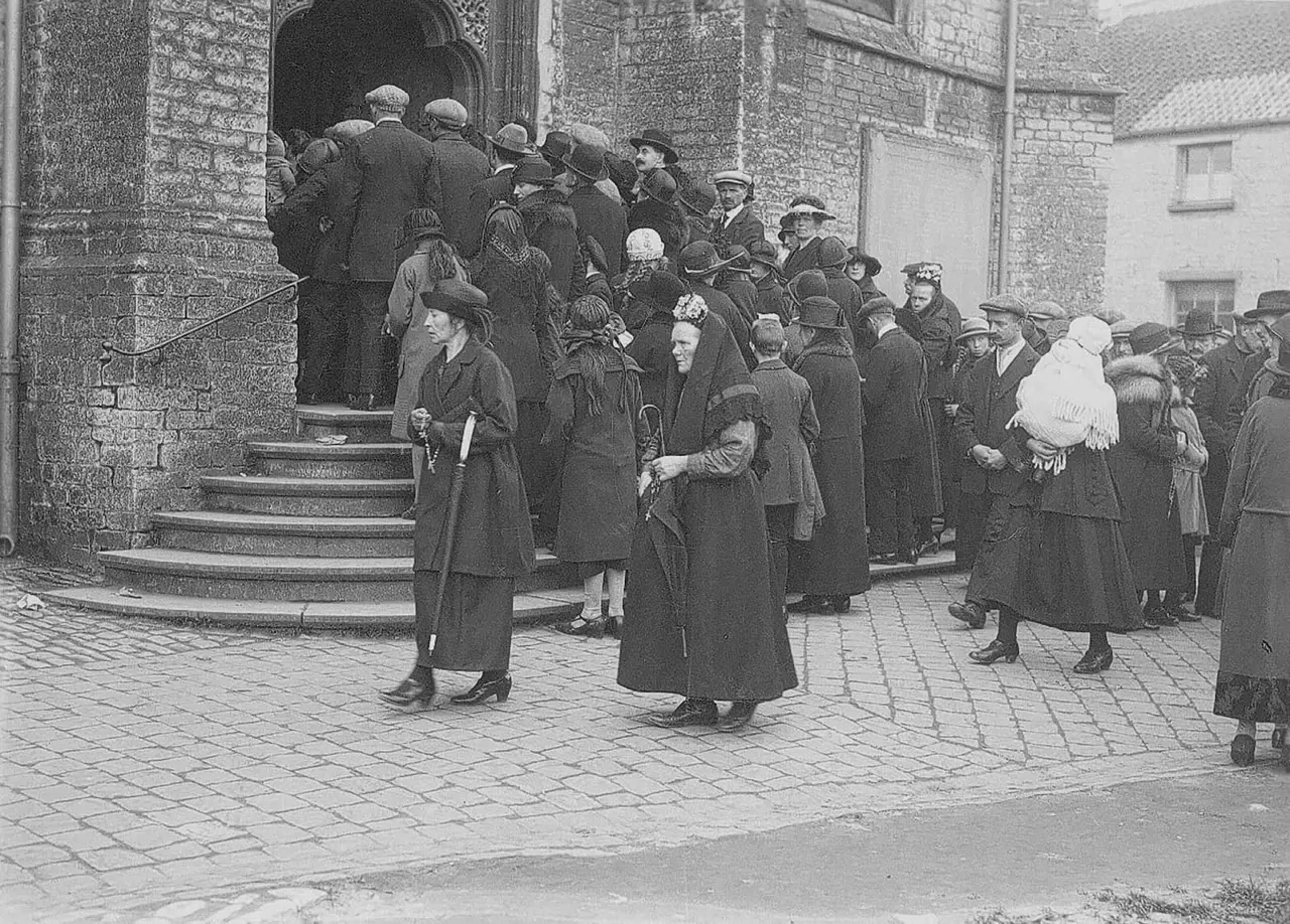 Oude foto: menigte bedevaarders bij de kerkingang.